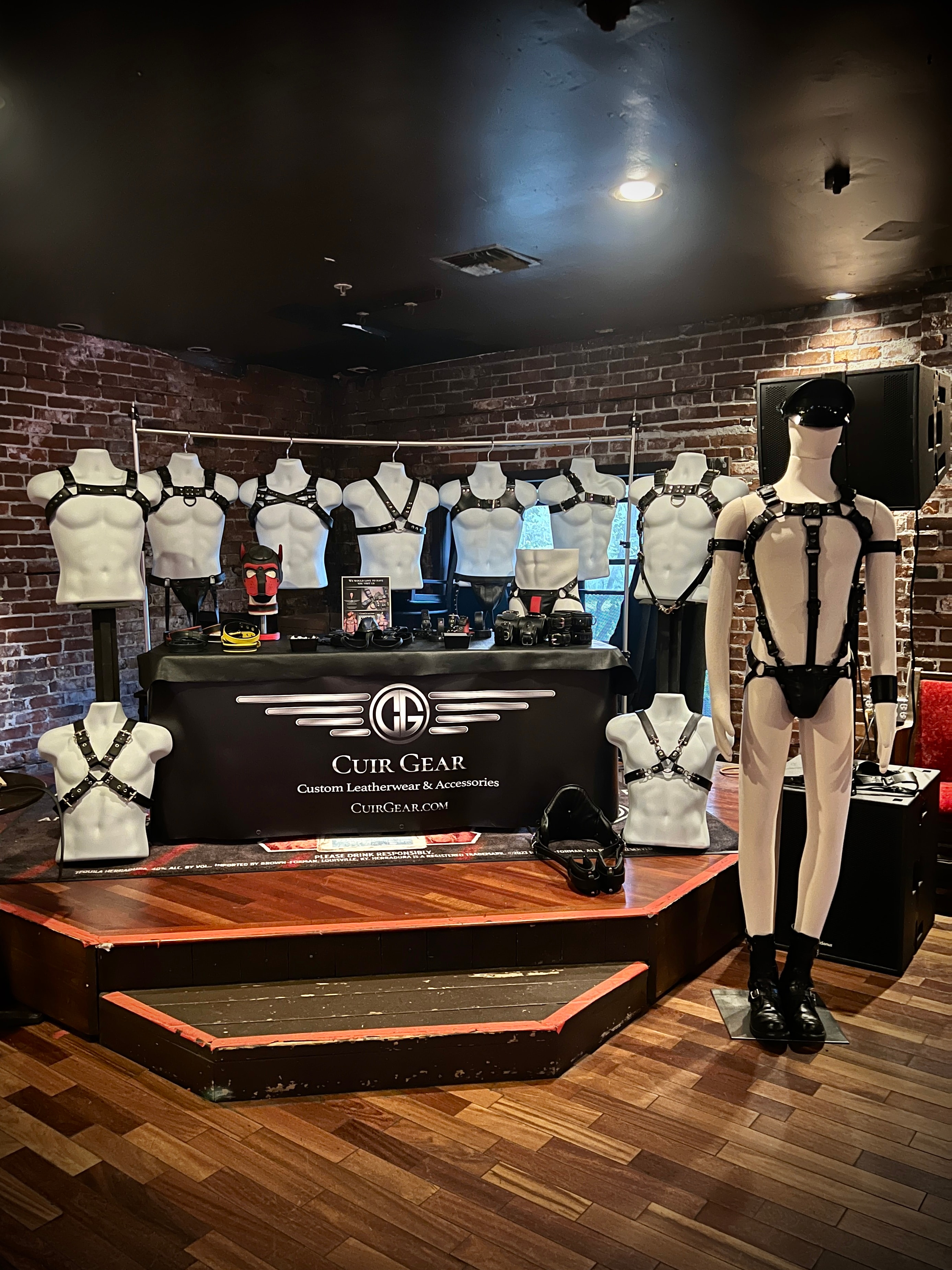 Cuir Gear trade show booth with harnesses on mannequins