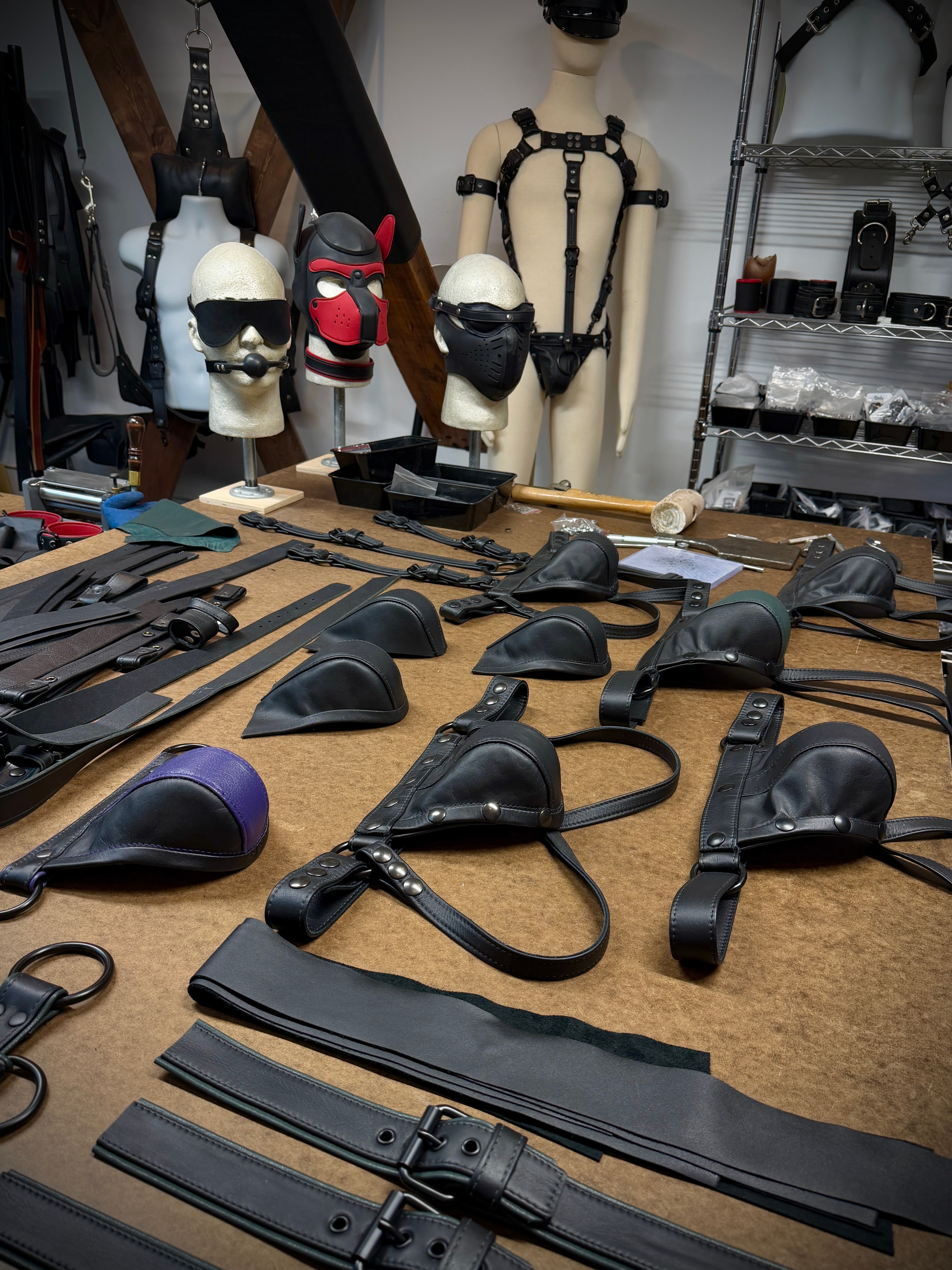 Workshop table covered in leather jockstraps and gear