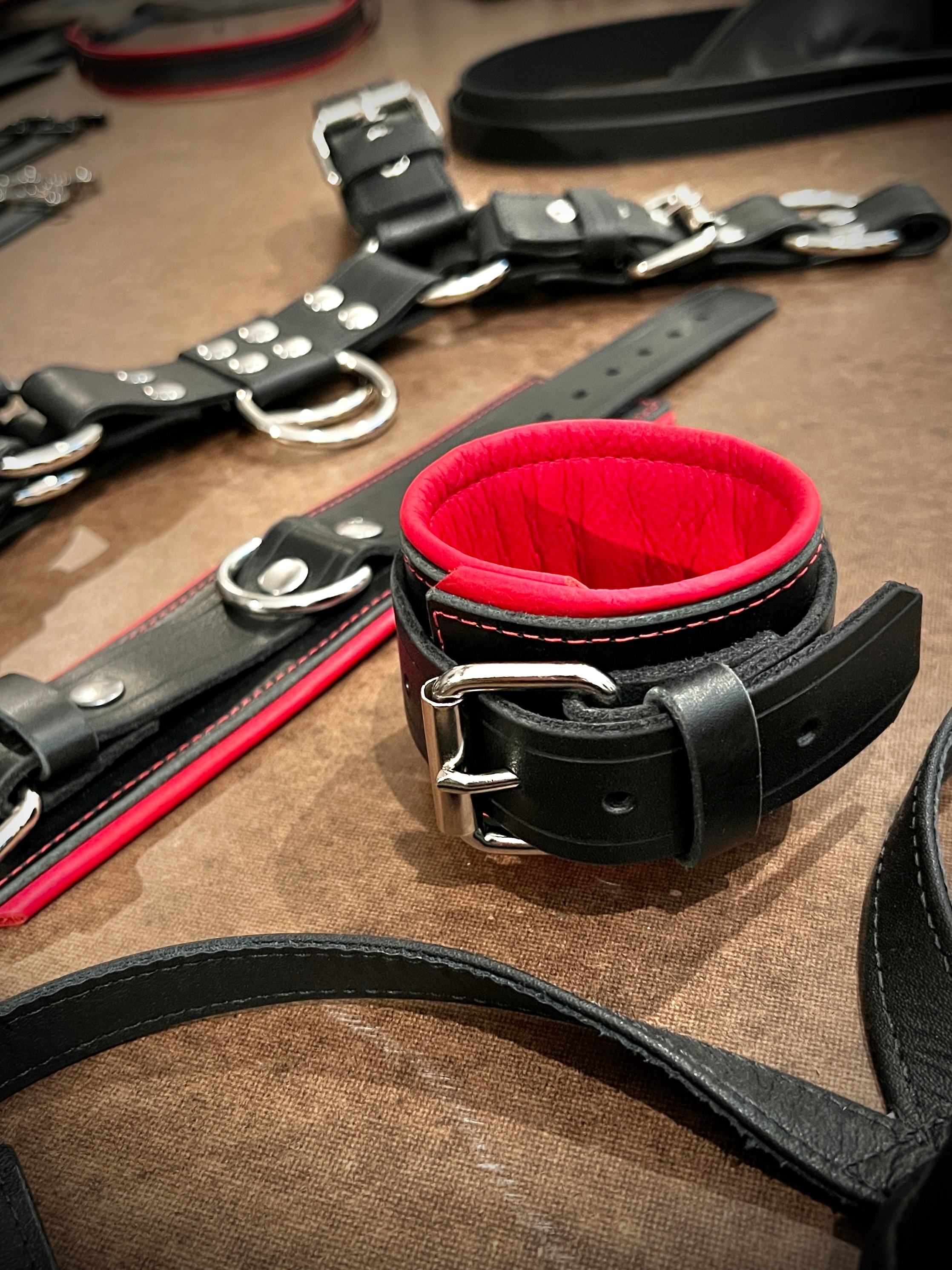 Black and red padded wrist cuff with restraints on table